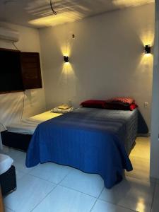 a bedroom with a bed with a blue blanket at Casa Completa Proximo ao Frances in Marechal Deodoro