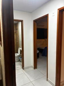 a bathroom with a toilet and a door to a room at Casa Completa Proximo ao Frances in Marechal Deodoro