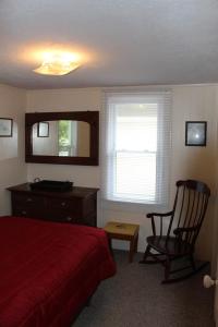 a bedroom with a bed and a chair and a mirror at Dockside Lake Resort in Monticello