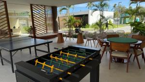 a ping pong table in a room with tables and chairs at Flat Inteiro no Makia Beach Experience in Porto De Galinhas