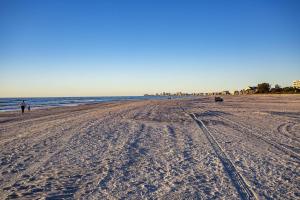 a beach with tire tracks in the sand at 501-S - Sunset Vistas in St. Pete Beach