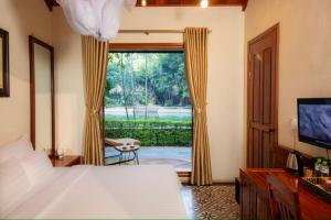 a bedroom with a bed and a large window at Hang Mua Ecolodge in Ninh Binh
