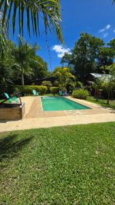 a swimming pool in a yard with a green lawn at Cabaña UNO Refugio in Paso de la Patria