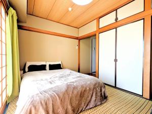 a bedroom with a bed and a sliding glass door at Apt熱海 in Atami
