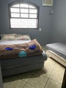 a bedroom with a bed and a window and a couch at Casa do Cleber in Matinhos