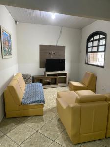 a living room with two couches and a flat screen tv at Casa do Cleber in Matinhos