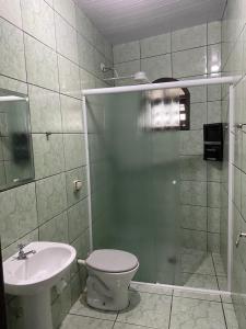 a bathroom with a shower and a toilet and a sink at Casa do Cleber in Matinhos
