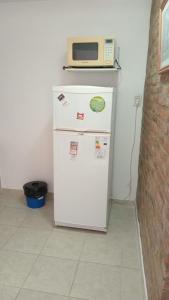 a white refrigerator with a microwave on top of it at Abuela Chiquita in Ramallo