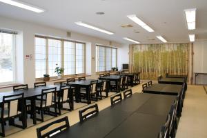 a large room with tables and chairs and windows at Karurusu Onsen Yumoto Orofuresou in Noboribetsu
