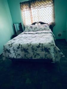 a bedroom with a bed with a floral bedspread at LAMBS LODGE, RESTURANT & CooL SPOT in Ontario Village