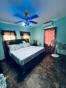 a bedroom with a bed and a ceiling fan at LAMBS LODGE, RESTURANT & CooL SPOT in Ontario Village