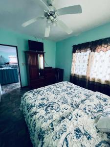 a bedroom with a bed and a ceiling fan at LAMBS LODGE, RESTURANT & CooL SPOT in Ontario Village