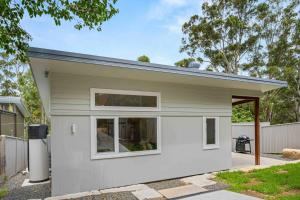 a white tiny house with a window at Blenheim Breeze by Experience Jervis Bay in Vincentia