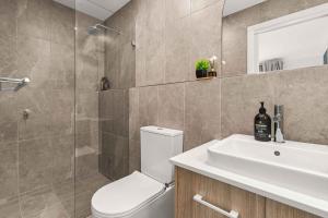 a bathroom with a toilet and a sink and a shower at Blenheim Breeze by Experience Jervis Bay in Vincentia +9 photos