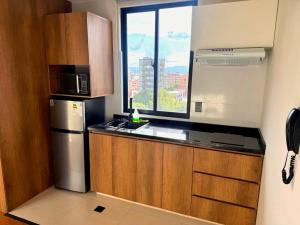 a small kitchen with a refrigerator and a window at Urban Escape Sky View in Cochabamba