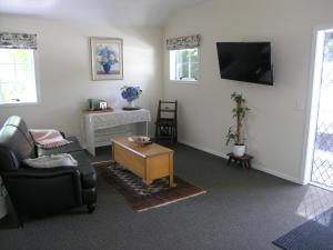 a living room with a couch and a tv at Woodhey Retreat Unit 2 in Karapiro