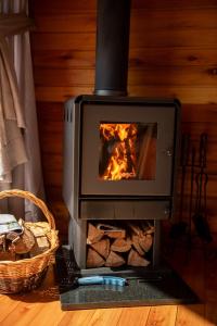a stove in a room with a fire in it at Cabana Terra - Hidro com vista, Lareira e Café da manhã in Nova Petrópolis +52 photos