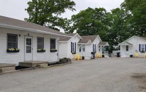 a row of white houses with yellow chairs outside at Dockside Lake Resort in Monticello