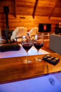 two glasses of red wine sitting on a counter at Cabana Terra - Hidro com vista, Lareira e Café da manhã in Nova Petrópolis