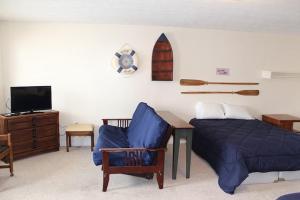 a bedroom with a bed and a table and a tv at Dockside Lake Resort in Monticello