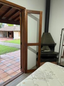 a glass door leading to a bedroom with a stove at Recanto do sossego in Gravataí