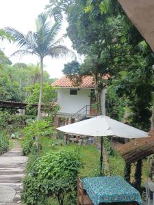 a table with an umbrella in front of a house at Bosque de Ángeles in Buena Vista