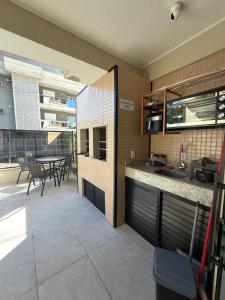 a kitchen and dining area of a building with a table at Residencial YÜMA in Bombinhas