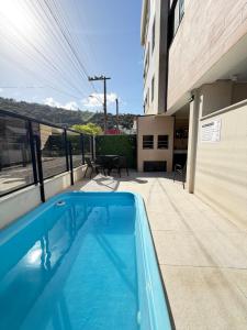 a swimming pool on the balcony of a building at Residencial YÜMA in Bombinhas