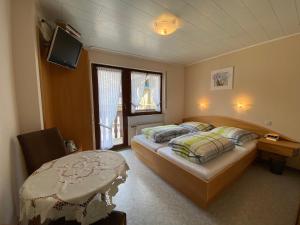 a bedroom with a bed and a tv on the wall at Gästehaus im Oberdorf in Erden