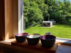three bowls sitting on a window sill looking out at a yard at Home Near Beach With Wilderness Bath in Sindrup