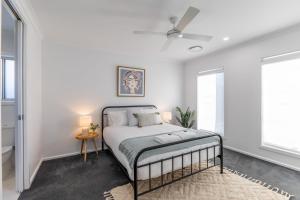 a bedroom with a bed and two windows at Lavender & Olive in Myrtleford
