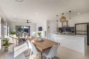 a kitchen and dining room with a wooden table and chairs at Lavender & Olive in Myrtleford +20 photos