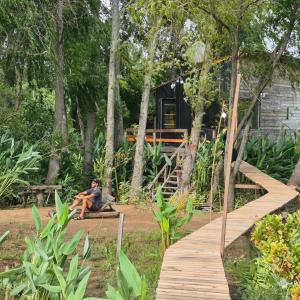 a man sitting on a bench in front of a house at La poderosa delta tigre in Tigre
