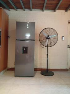 a fan in a room next to a refrigerator at Morada de Duendes in Sauce Viejo