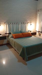a bedroom with a bed with orange and blue sheets at Morada de Duendes in Sauce Viejo