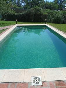 a swimming pool with blue water in a yard at Morada de Duendes in Sauce Viejo +8 photos