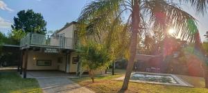 a palm tree in front of a building at Morada de Duendes in Sauce Viejo