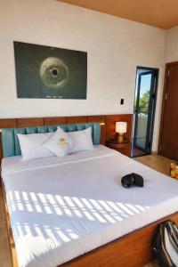 a bedroom with a large white bed with a hat on it at Hôtel De Da Phu in Da Lat