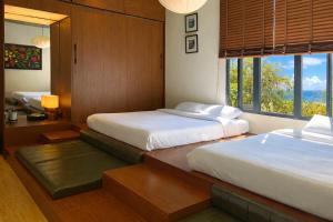 a bedroom with two beds and a window at Hôtel De Da Phu in Da Lat