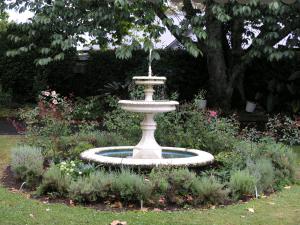 a fountain in the middle of a garden at Woodhey Retreat Unit 2 in Karapiro