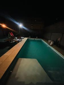 an empty swimming pool at night with lights at Casa de luz in Posadas