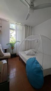 a bedroom with a white bed with a blue bag on the floor at Comme à la maison! Le Moule in Le Moule +7 photos