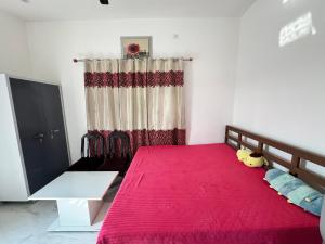 a bedroom with a large bed with a red blanket at Panwar peaceful homestay in Jhājra