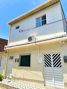 a white house with a garage at Torres Residence 2 in Recife