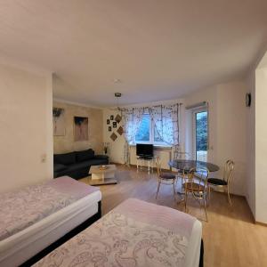 a bedroom with a bed and a living room with a table at Apartment Weimar II in Ulla