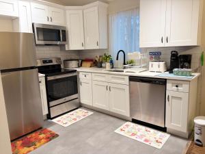 a kitchen with white cabinets and stainless steel appliances at Evergreen Escapes 4 BR with Game Room, Firepit near Kalahari and Camelback in Long Pond