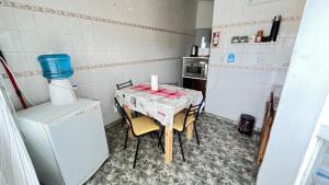 a small kitchen with a table and a refrigerator at Estrellas del Sur in Río Gallegos +4 photos