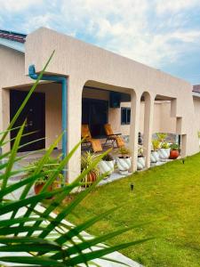 a building with a patio with chairs and grass at Bendo house in Accra