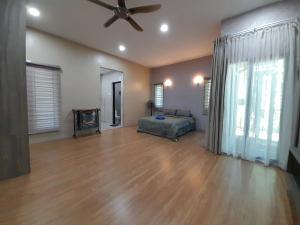 a living room with a bed and a ceiling fan at Teratak Assofiyya 4 Bilik in Sungai Petani
