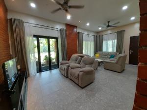 a living room with two couches and a tv at Teratak Assofiyya 4 Bilik in Sungai Petani